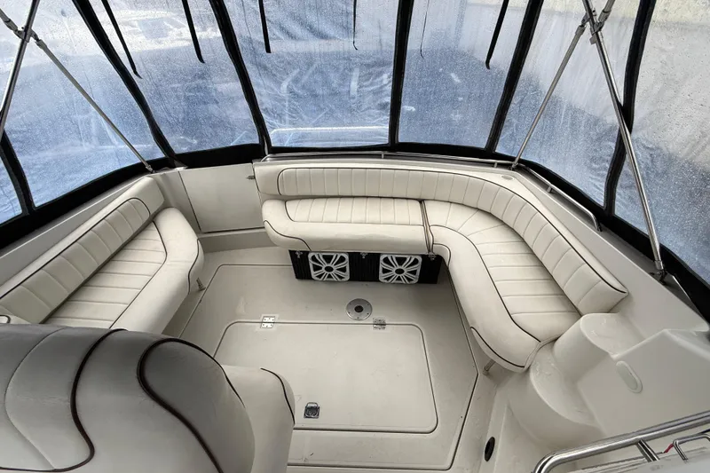 Slide: The Image of 1997 Larson Cabrio 310 Mid-Cabin boat interior with white seating and clear canopy. - 8
