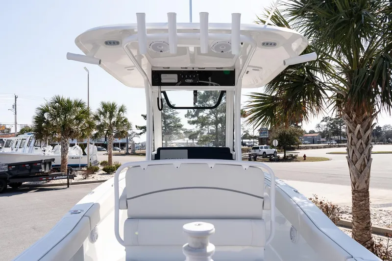 Slide: The Image of 2023 Sea Hunt Ultra 239 SE boat with T-top, parked near palm trees. - 11