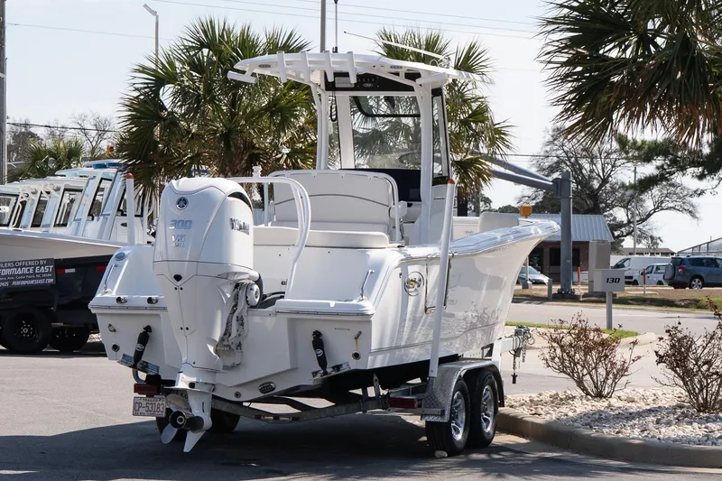 Slide: The Image of 2023 Sea Hunt Ultra 239 SE boat on trailer, parked near palm trees. - 6