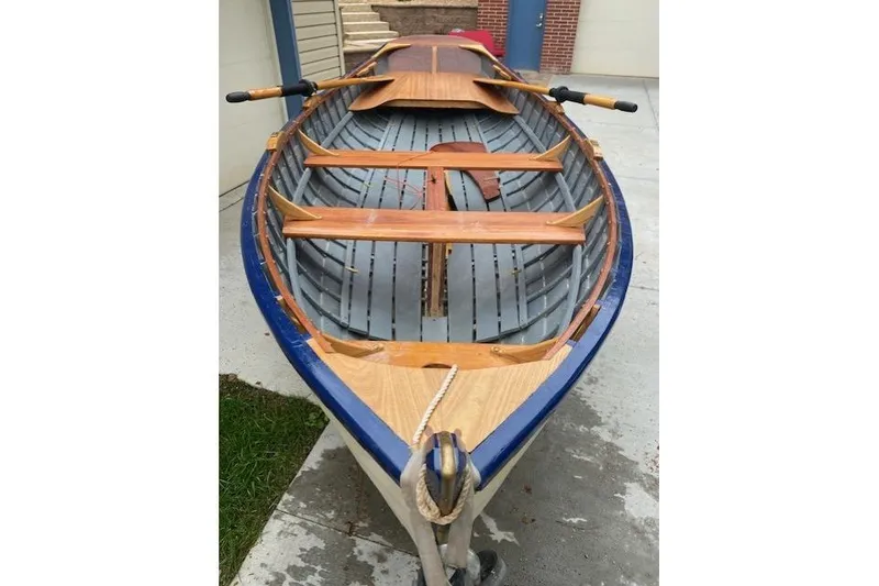 Slide: The Image of Home-built 2019 Cat's Paw boat with wooden interior and blue trim, docked outdoors. - 14