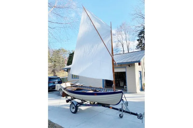 Slide: The Image of Home-built 2019 Cat's Paw sailboat on trailer, parked outside a garage. - 18