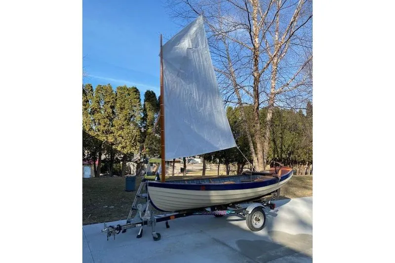 Slide: The Image of Home-built 2019 Cat's Paw sailboat on trailer, set against a clear blue sky. - 4