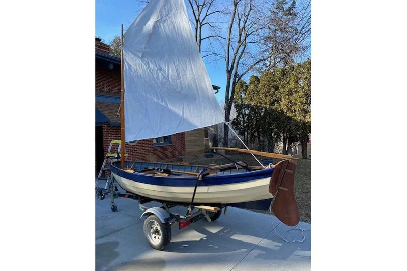 Slide: The Image of Home-built 2019 Cat's Paw sailboat on trailer, white sail, outdoor setting. - 5
