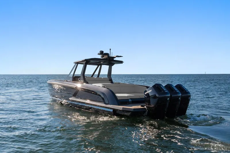 Slide: The Image of 2024 Vanquish Yachts 40 on open water, featuring sleek design and triple outboard engines. - 16