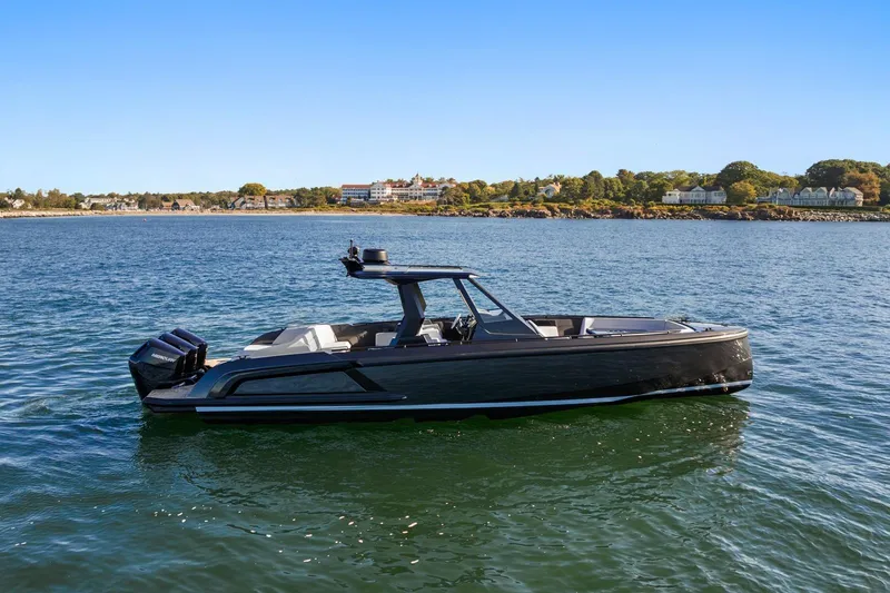 Slide: The Image of 2024 Vanquish Yachts 40 on serene water with scenic shoreline background. - 19