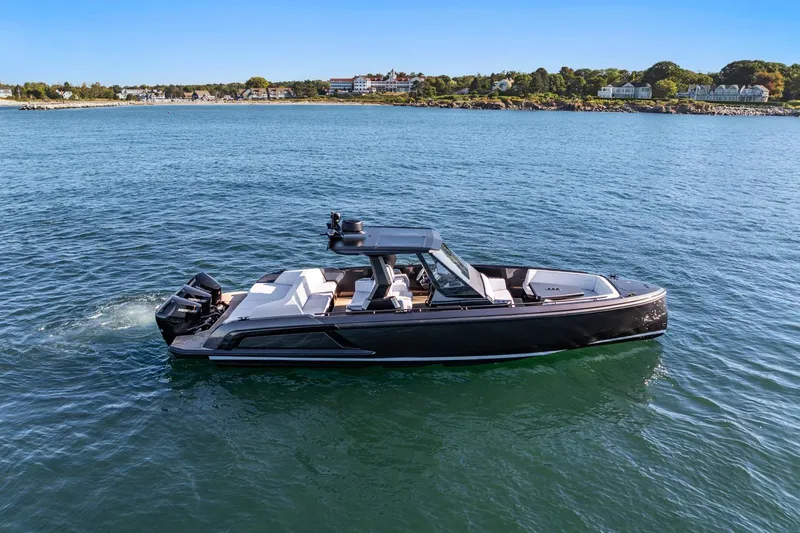 Slide: The Image of 2024 Vanquish Yachts 40 cruising on calm waters near a scenic coastline. - 29