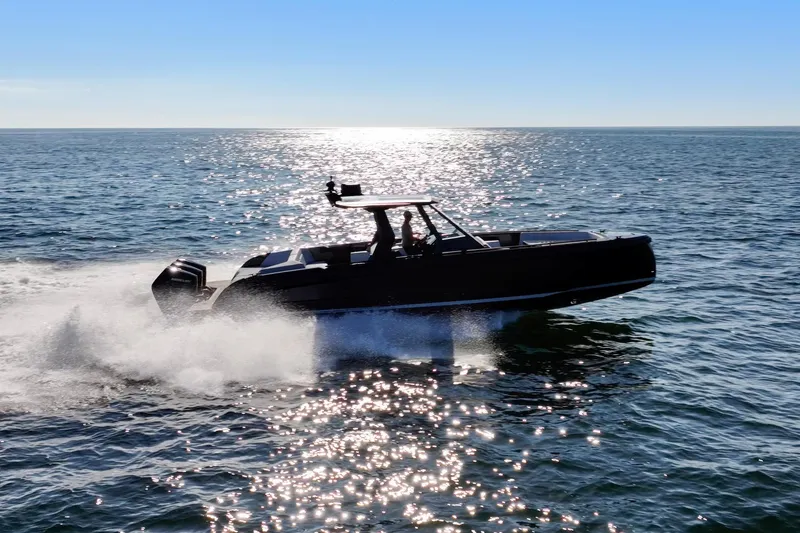 Slide: The Image of 2024 Vanquish Yachts 40 cruising on open water under clear blue sky. - 3