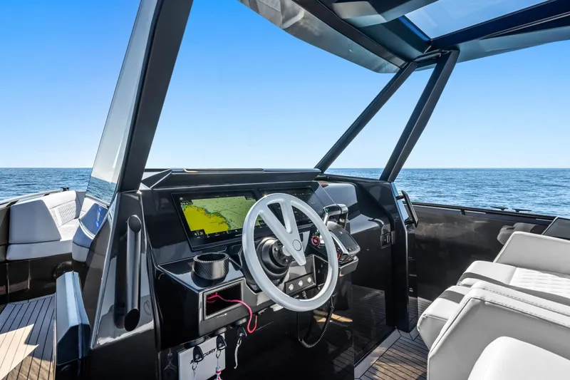 Slide: The Image of 2024 Vanquish Yachts 40 cockpit with modern steering and navigation system, ocean view. - 39