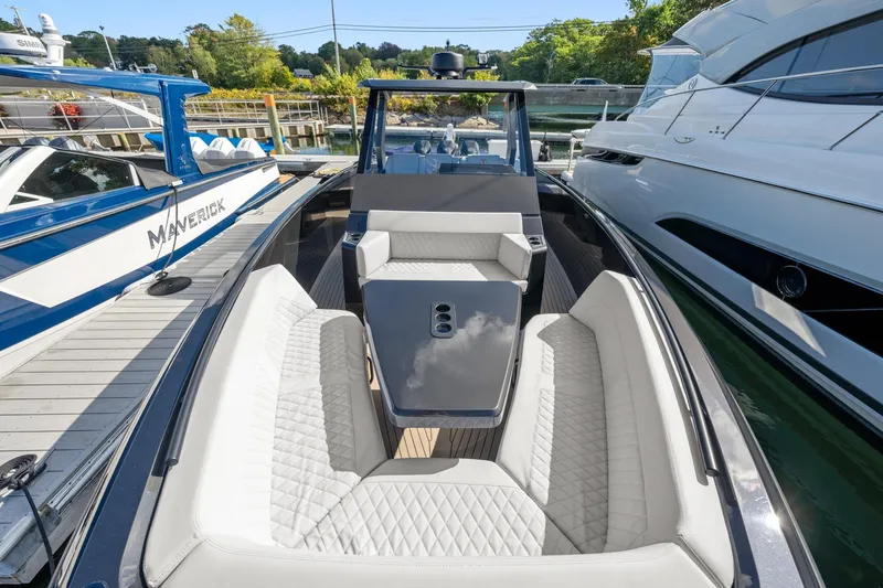 Slide: The Image of 2024 Vanquish Yachts 40 with luxurious seating, docked alongside other boats. - 50