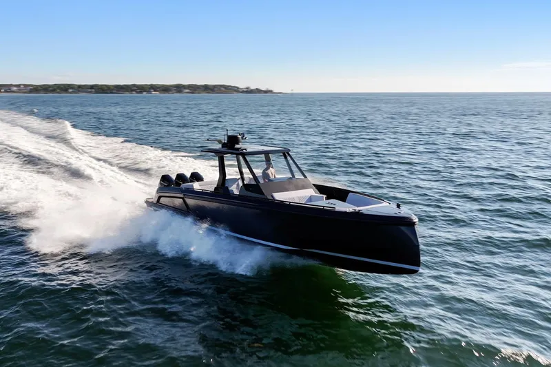 Slide: The Image of 2024 Vanquish Yachts 40 cruising swiftly on open water under clear blue skies. - 7