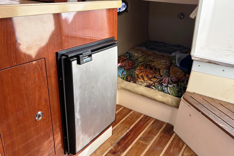 Slide: The Image of 2011 Regal 2565 Express Cruiser interior with wood cabinetry and cozy sleeping area. - 12