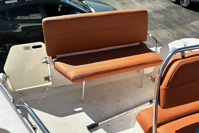 Slide: The Image of 2011 Regal 2565 Express Cruiser boat seating area with orange cushions. - 2