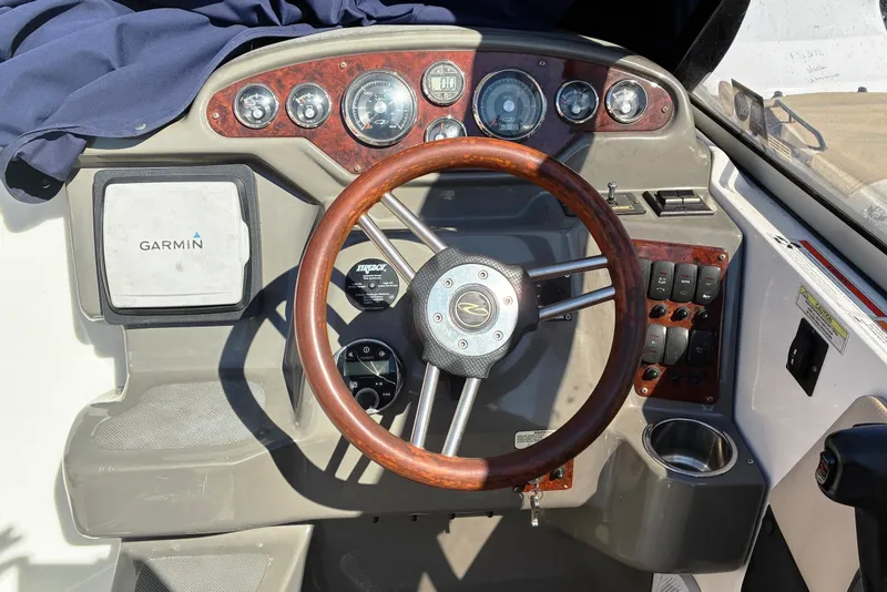Slide: The Image of 2011 Regal 2565 Express Cruiser dashboard with Garmin navigation and wooden steering wheel. - 7