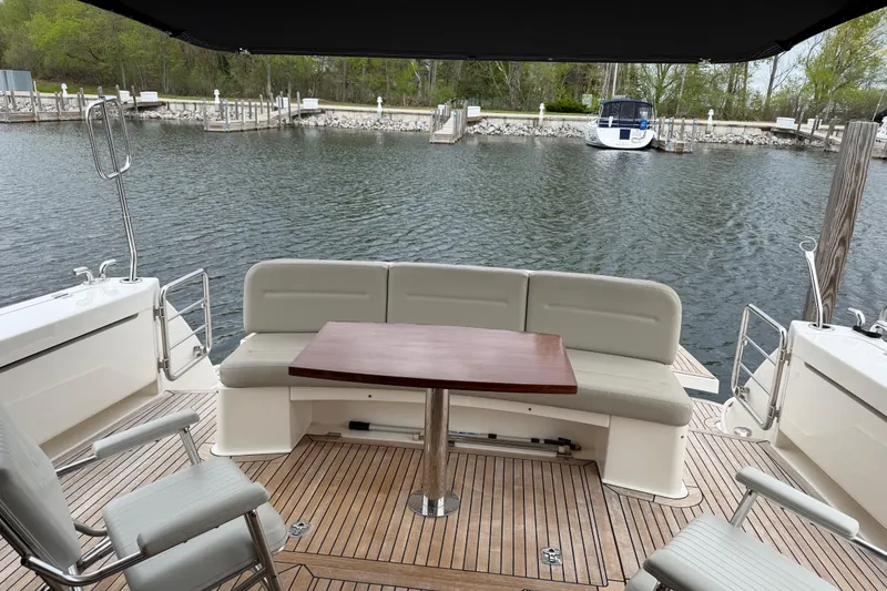 Slide: The Image of 2017 Maritimo M54 yacht deck with seating and table, docked by calm waters. - 4