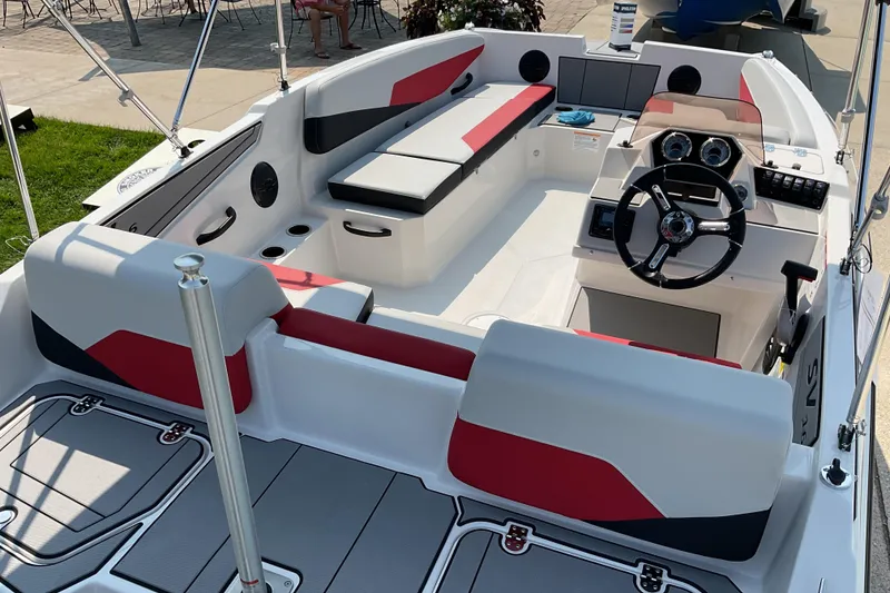Slide: The Image of 2026 Starcraft SV 16 OB boat interior with red and gray seating, steering console, and cup holders. - 6
