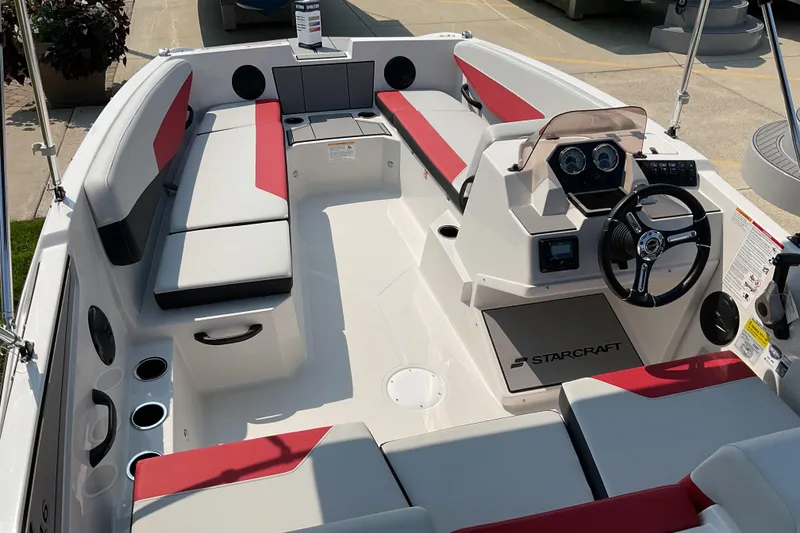 Slide: The Image of 2026 Starcraft SV 16 OB boat interior with red and gray seating, modern dashboard, and cup holders. - 7