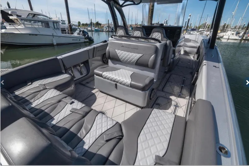 Slide: The Image of 2020 Midnight Express 37 Open boat interior with luxurious seating in a marina setting. - 5