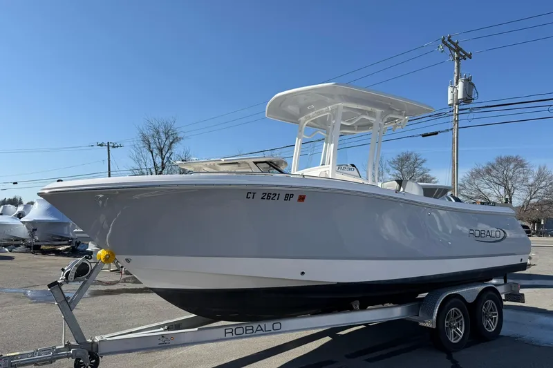 The Image of 2022 Robalo R230 Center Console boat on trailer under clear blue sky. - 19