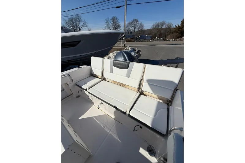 Slide: The Image of 2022 Robalo R230 Center Console boat with white seating and outdoor setting. - 24