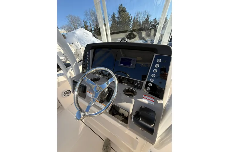 Slide: The Image of 2022 Robalo R230 Center Console boat dashboard with steering wheel and controls. - 30