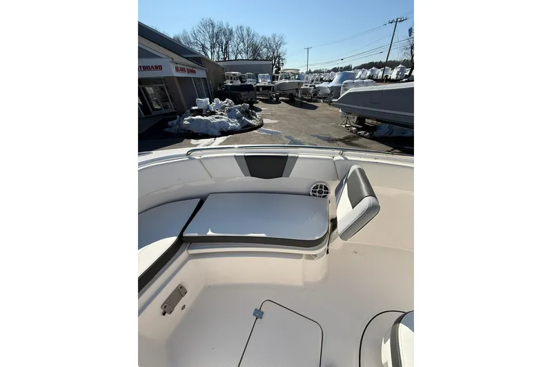 Slide: The Image of 2022 Robalo R230 Center Console boat interior with seating and storage, outdoor dealership setting. - 37