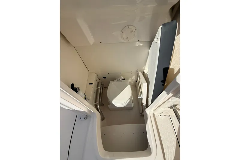 Slide: The Image of 2022 Robalo R230 Center Console boat interior with compact marine toilet. - 38