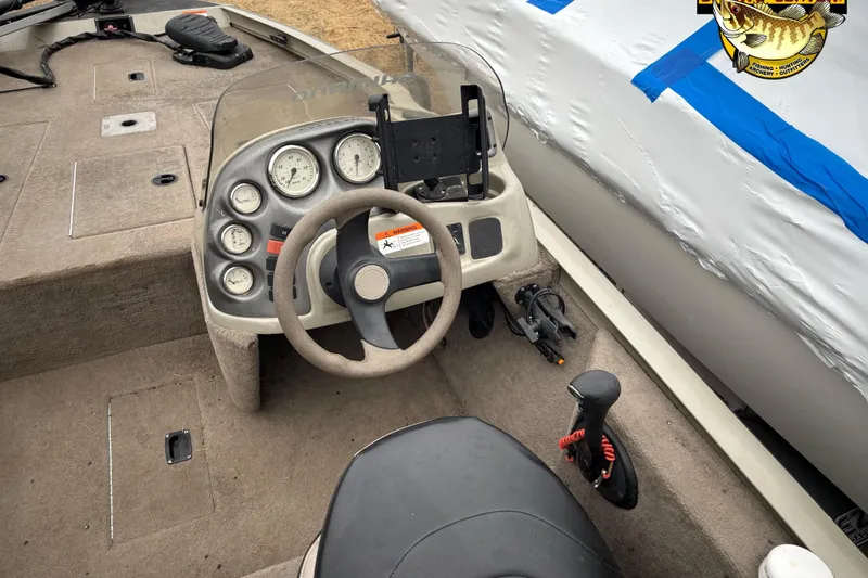 Slide: The Image of 2005 Lowe Stinger 170W boat dashboard with steering wheel and instrument panel. - 6