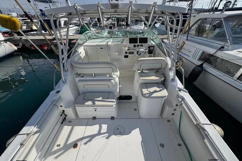 Slide: The Image of 2007 Wellcraft 290 Coastal boat interior, featuring helm and seating, docked at marina. - 10