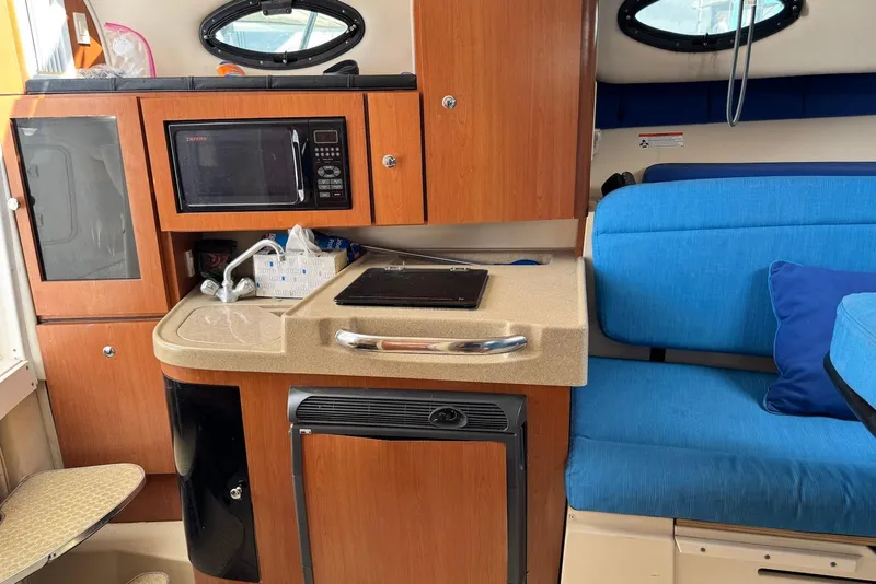 Slide: The Image of Interior of 2007 Wellcraft 290 Coastal boat with kitchenette and blue seating. - 17