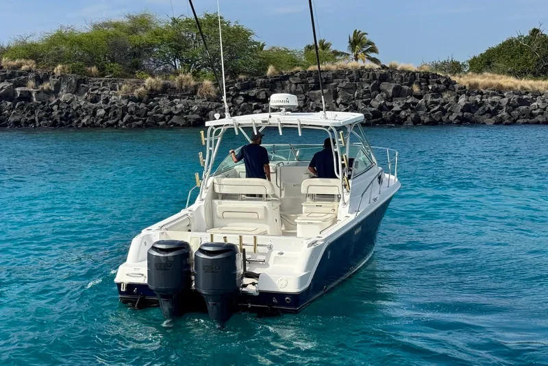 Slide: The Image of 2007 Wellcraft 290 Coastal boat cruising in clear blue waters near rocky shoreline. - 5