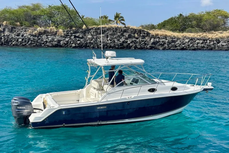 Slide: The Image of 2007 Wellcraft 290 Coastal boat on clear blue water near rocky shoreline. - 6