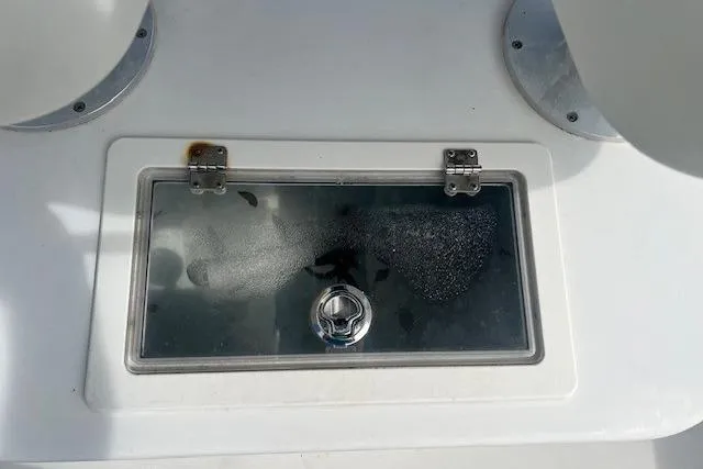 Slide: The Image of 2016 Parker 21SE Center Console boat hatch with glass cover and metal hinges. - 13