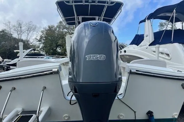 Slide: The Image of 2016 Parker 21SE Center Console boat with 150 horsepower engine, docked under a blue sky. - 17