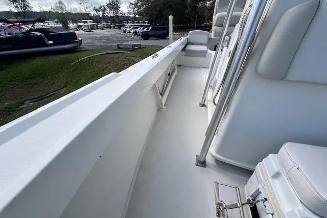 Slide: The Image of 2016 Parker 21SE Center Console boat interior with seating and railing, docked near other boats. - 9