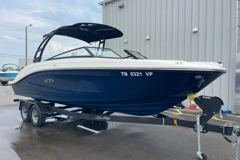 Slide: The Image of 2023 Sea Ray SPX 230 Outboard boat on trailer, blue hull, parked outdoors. - 10