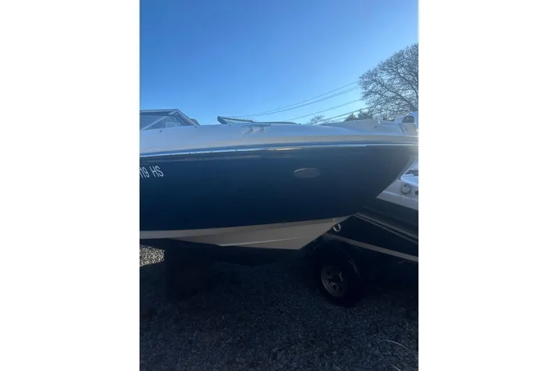 The Image of 2023 Sea Ray SPX 230 Outboard boat, blue hull, parked on gravel. - 11