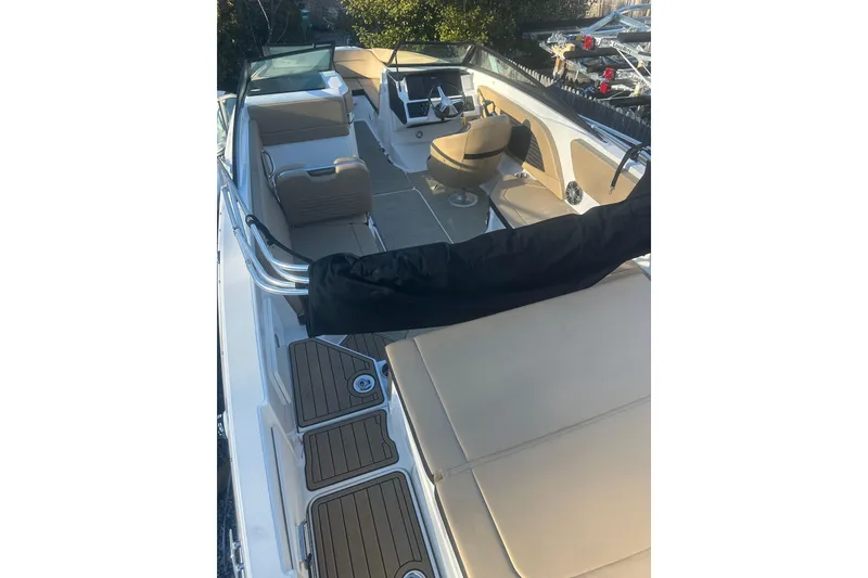 Slide: The Image of 2023 Sea Ray SPX 230 Outboard boat interior with beige seating and modern dashboard. - 16