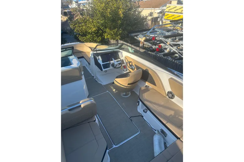Slide: The Image of 2023 Sea Ray SPX 230 Outboard boat interior with tan seating and steering console. - 19