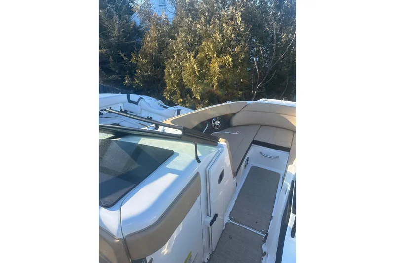 Slide: The Image of 2023 Sea Ray SPX 230 Outboard boat interior with beige seating and sleek design. - 21