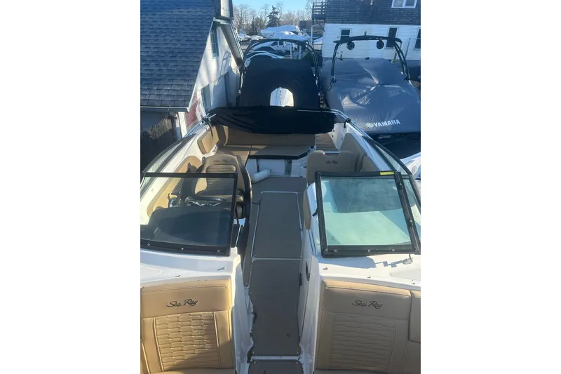 Slide: The Image of 2023 Sea Ray SPX 230 Outboard boat with tan interior, docked near other boats. - 22