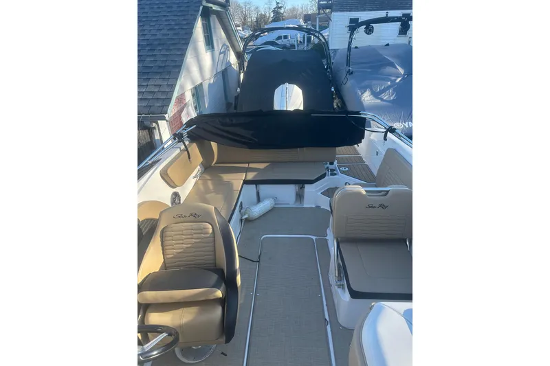 Slide: The Image of 2023 Sea Ray SPX 230 Outboard boat interior with tan seating and steering wheel. - 25