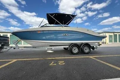 Slide: The Image of 2023 Sea Ray SPX 230 Outboard boat on trailer, blue hull, parked outdoors. - 6