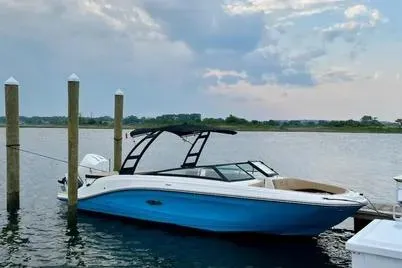 Slide: The Image of 2023 Sea Ray SPX 230 Outboard boat docked on calm water under cloudy sky. - 8