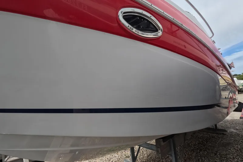 Slide: The Image of 2012 Four Winns V265 boat with red and white hull on a stand. - 19