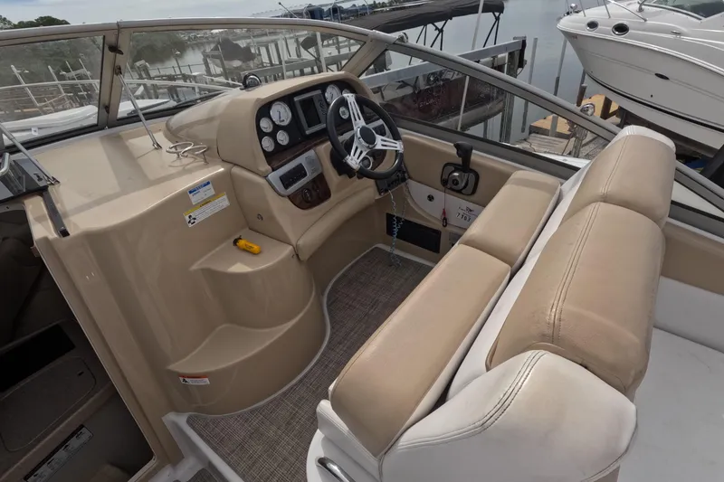 Slide: The Image of 2012 Four Winns V265 boat cockpit with steering wheel and beige seating. - 32
