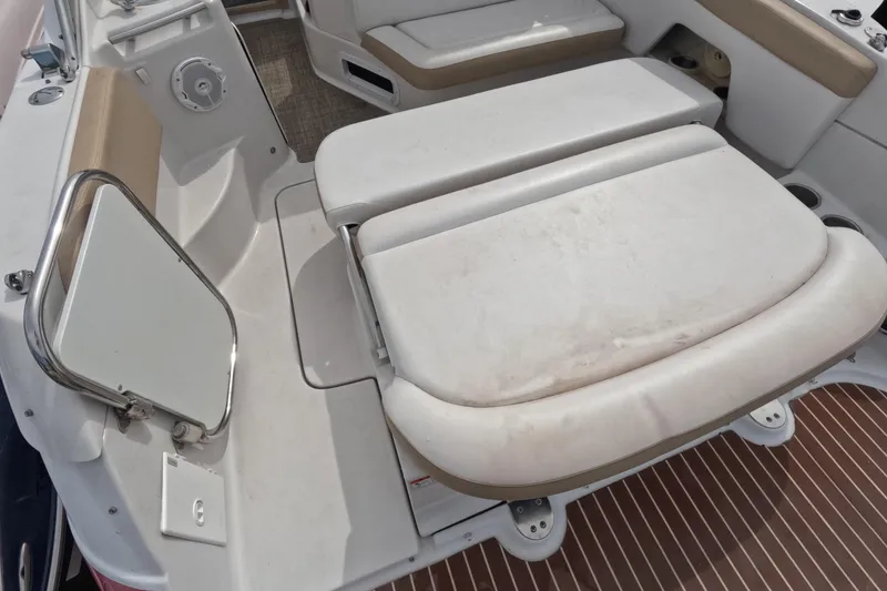 Slide: The Image of 2012 Four Winns V265 boat interior seating area with white and beige upholstery. - 75
