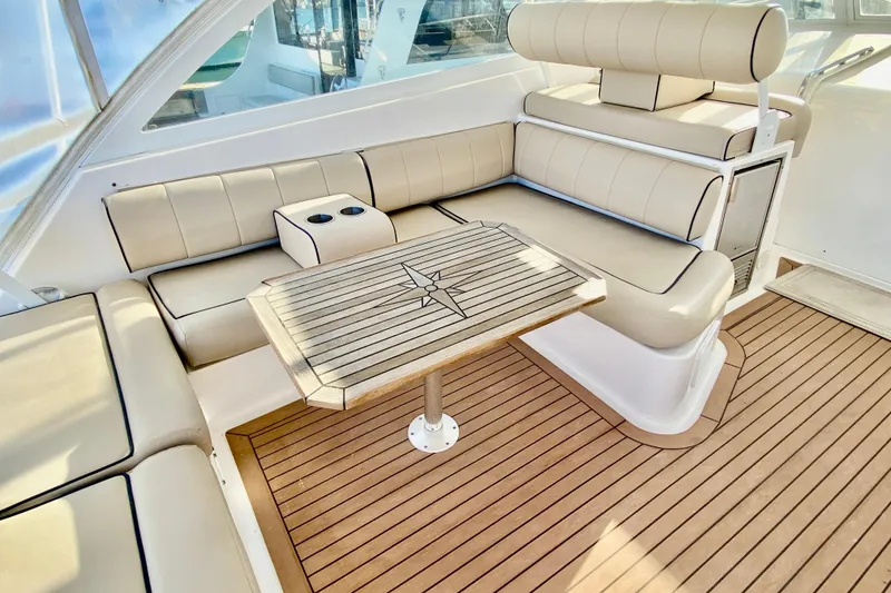 Slide: The Image of Luxurious seating area on 2006 Luhrs 41 Open yacht with wooden table and cup holders. - 13