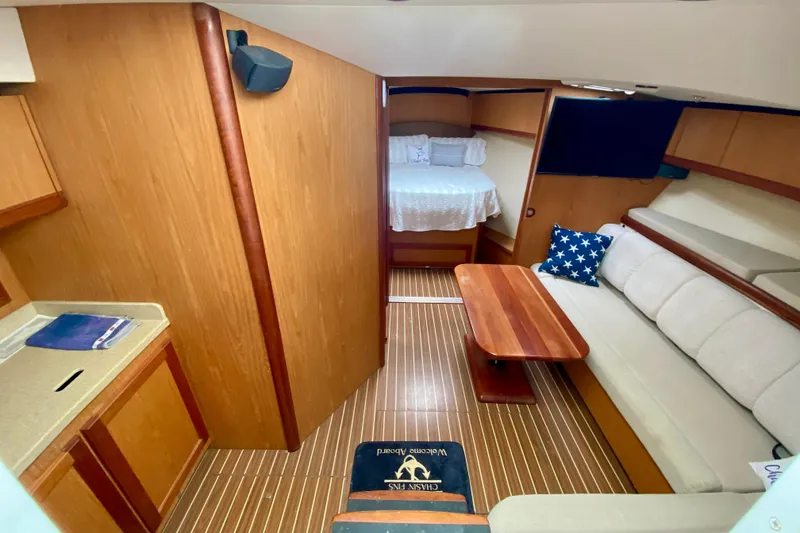 Slide: The Image of 2006 Luhrs 41 Open yacht interior with cozy seating, wooden table, and bed. - 17