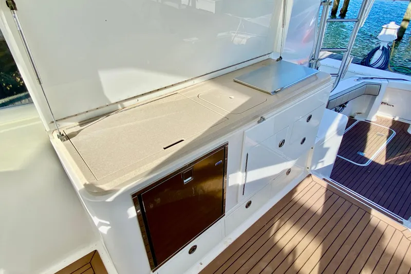 Slide: The Image of 2006 Luhrs 41 Open yacht deck with storage and seating, featuring sleek design and wood flooring. - 30