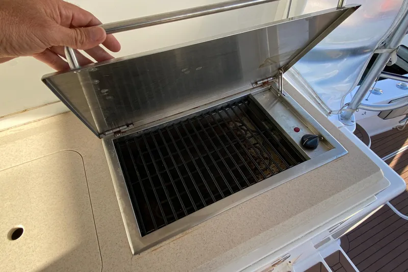 Slide: The Image of Built-in grill on 2006 Luhrs 41 Open yacht, featuring stainless steel cover and control knob. - 32